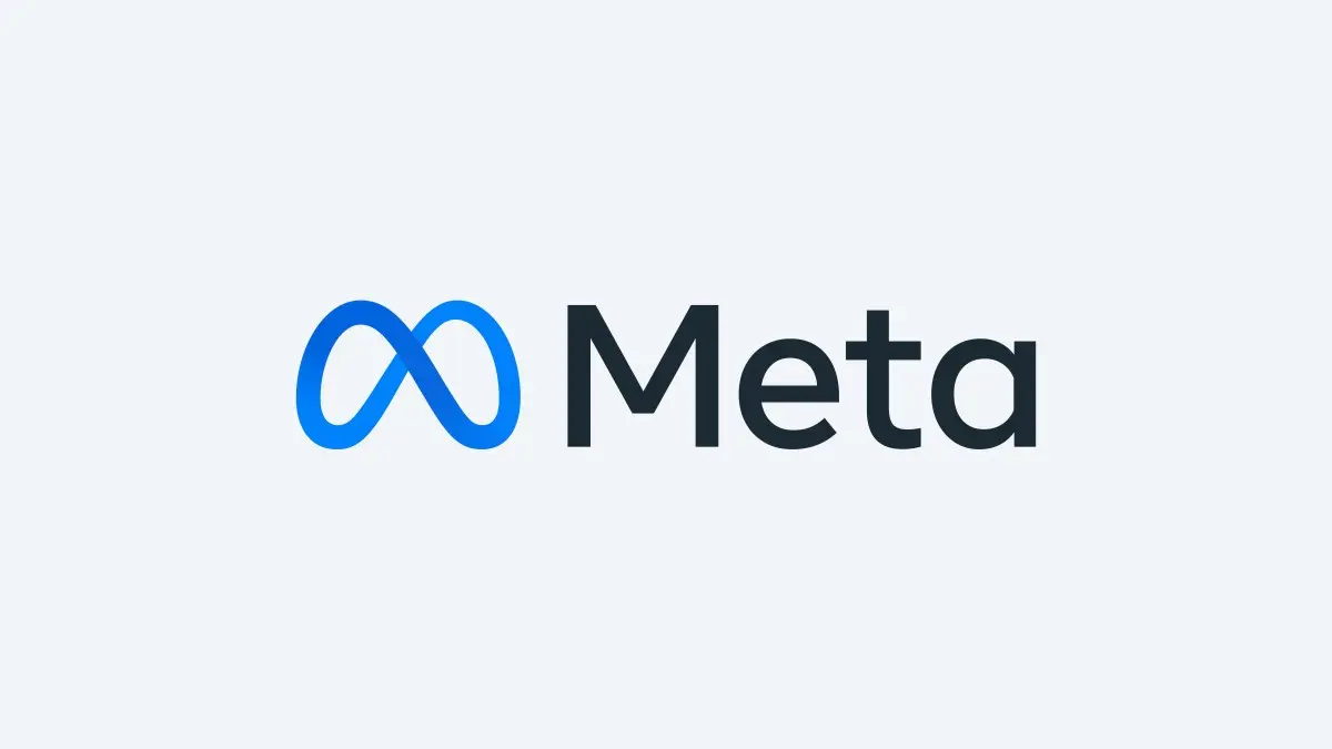The Meta wordmark and infinity logo in blue on a plain grey background, as used on the company's newsroom posts.