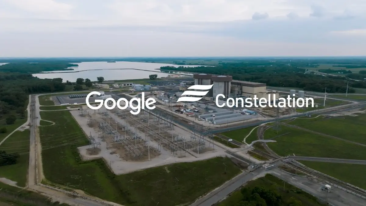 An aerial view of a nuclear power station beside a wide lake, surrounded by green fields and access roads, with the Google and Constellation wordmarks overlaid across the centre.