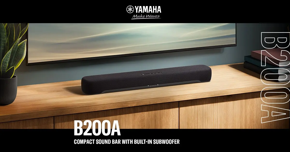 The Yamaha B200A compact sound bar sitting on a wooden cabinet beneath a wall-mounted television