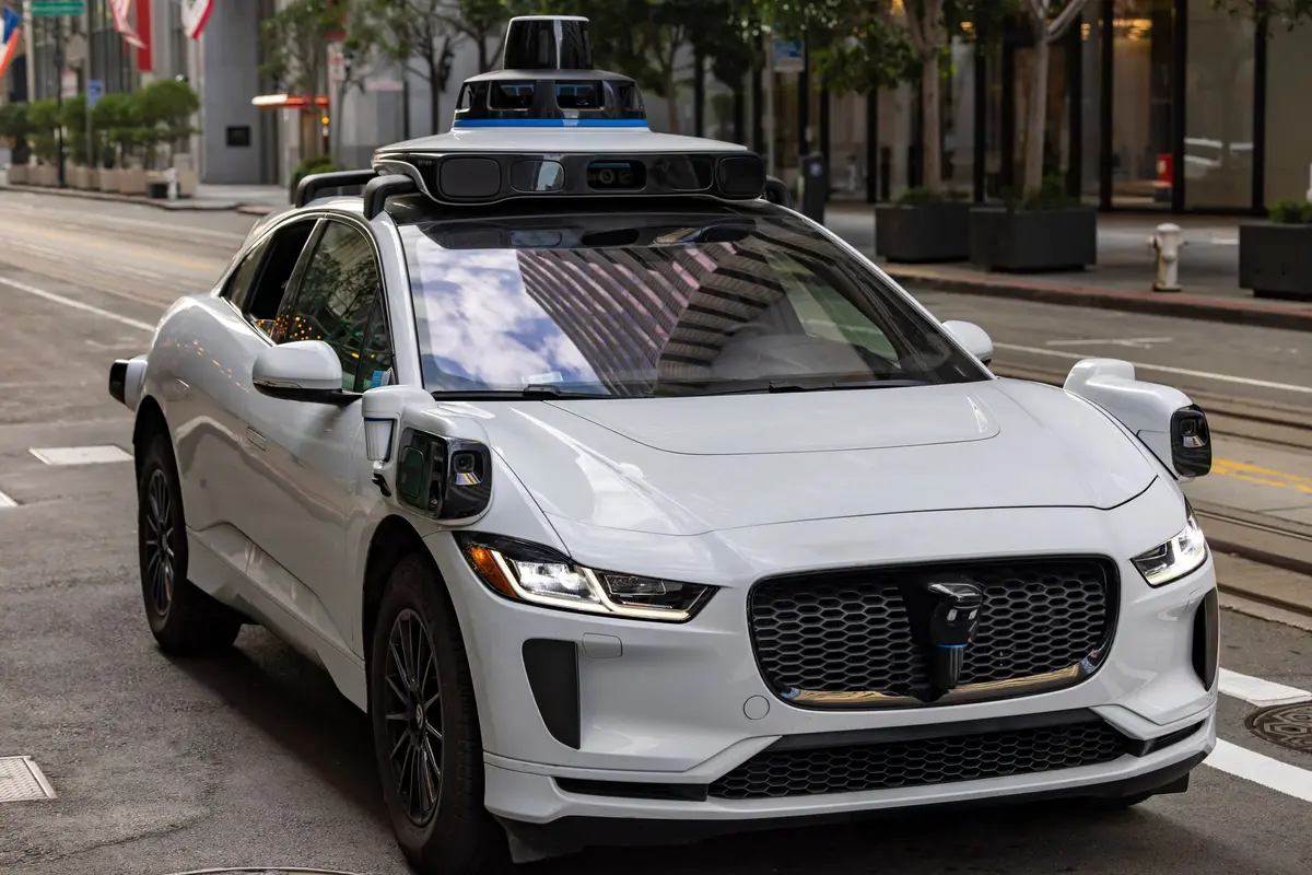 Illustrative photograph of a self-driving car travelling on an urban street.