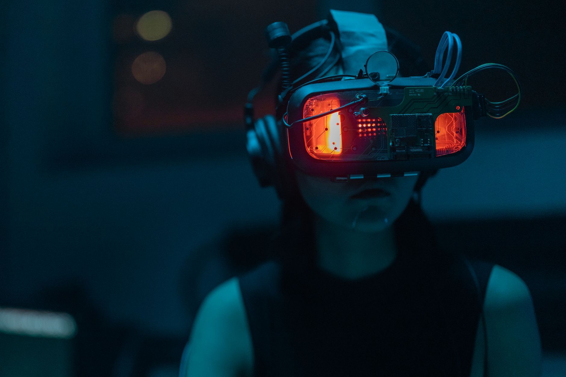 Imagen referencial: Una mujer sumergida en una experiencia de realidad virtual con un visor de VR de alta tecnología en una habitación poco iluminada.