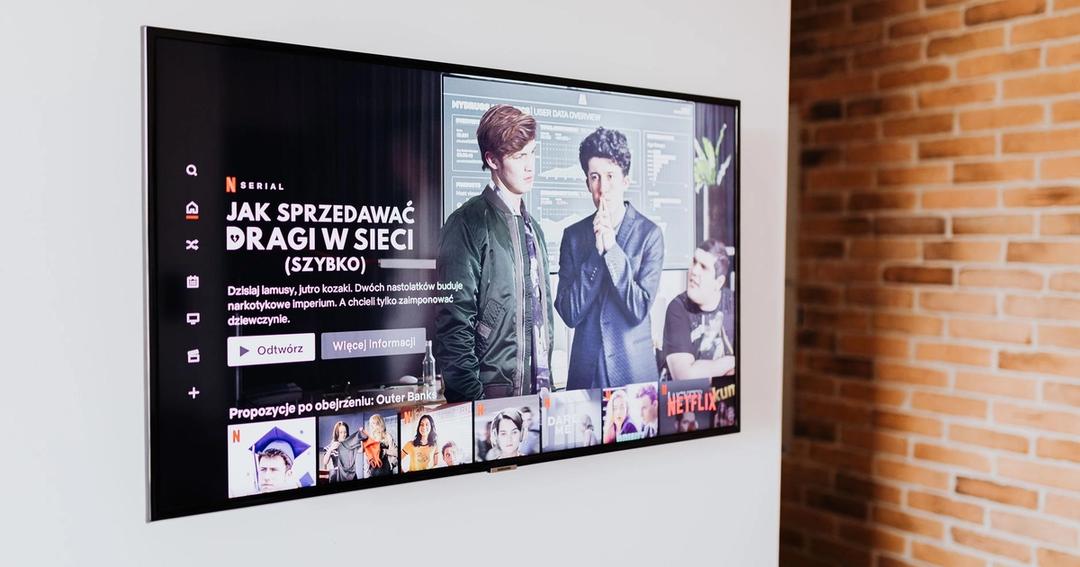 Imagen referencial: Smart TV mostrando contenido de streaming en un moderno salón con pared de ladrillo expuesto.