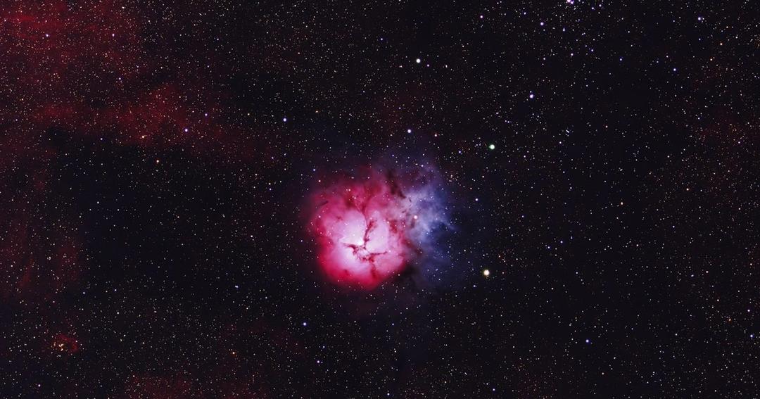 Imagen referencial: Captura impresionante de la Nebulosa Trifid mostrando sus colores vibrantes y un extenso campo estelar.