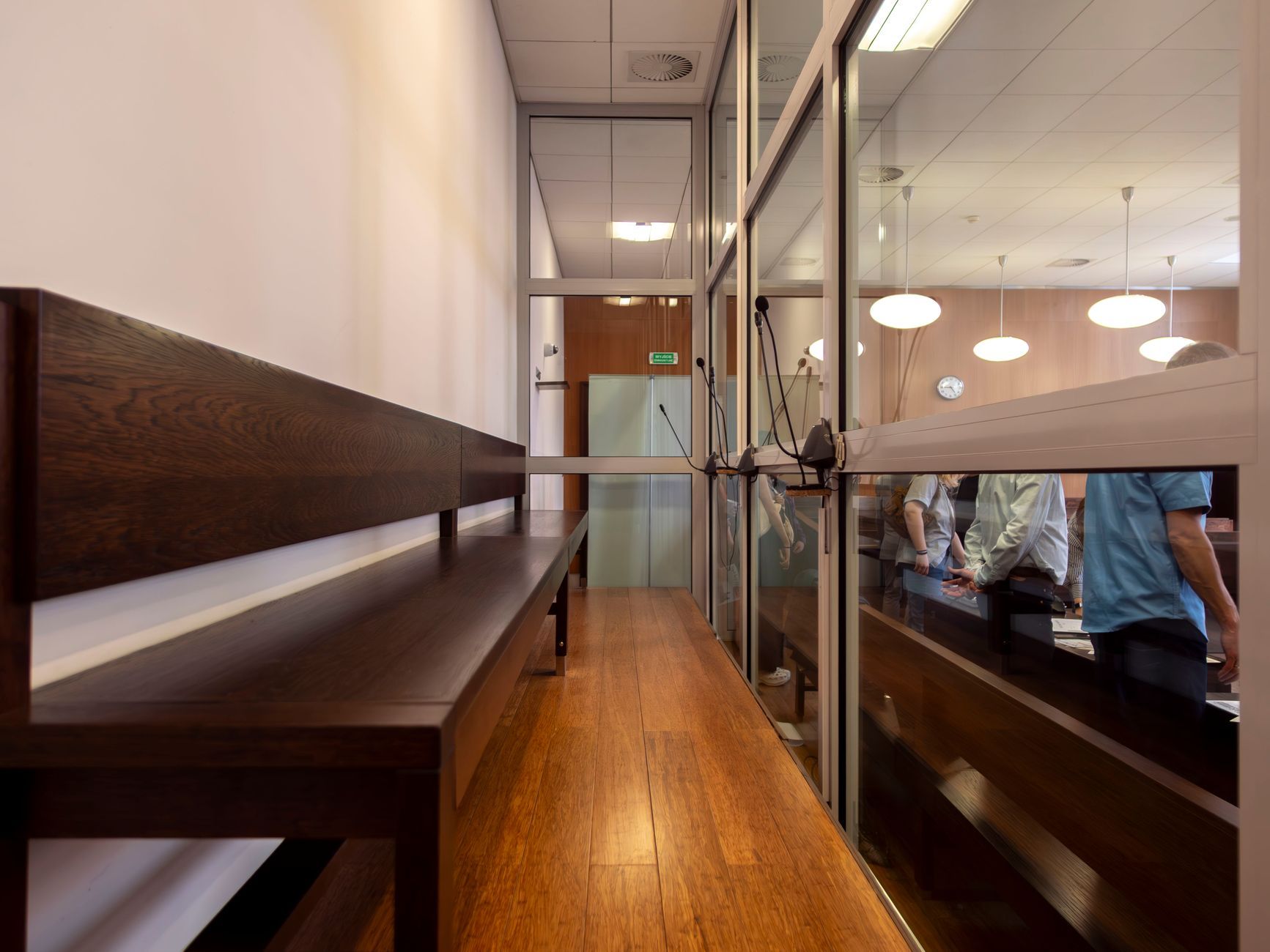 Imagen referencial: Vista interior de una sala de audiencias en Breslavia, Polonia, con bancos de madera y mamparas de cristal.