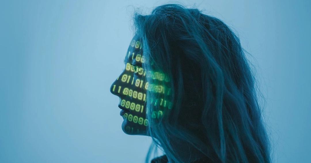 Imagen referencial: Silueta de una mujer con código binario proyectado en su cara en un entorno de concepto digital.