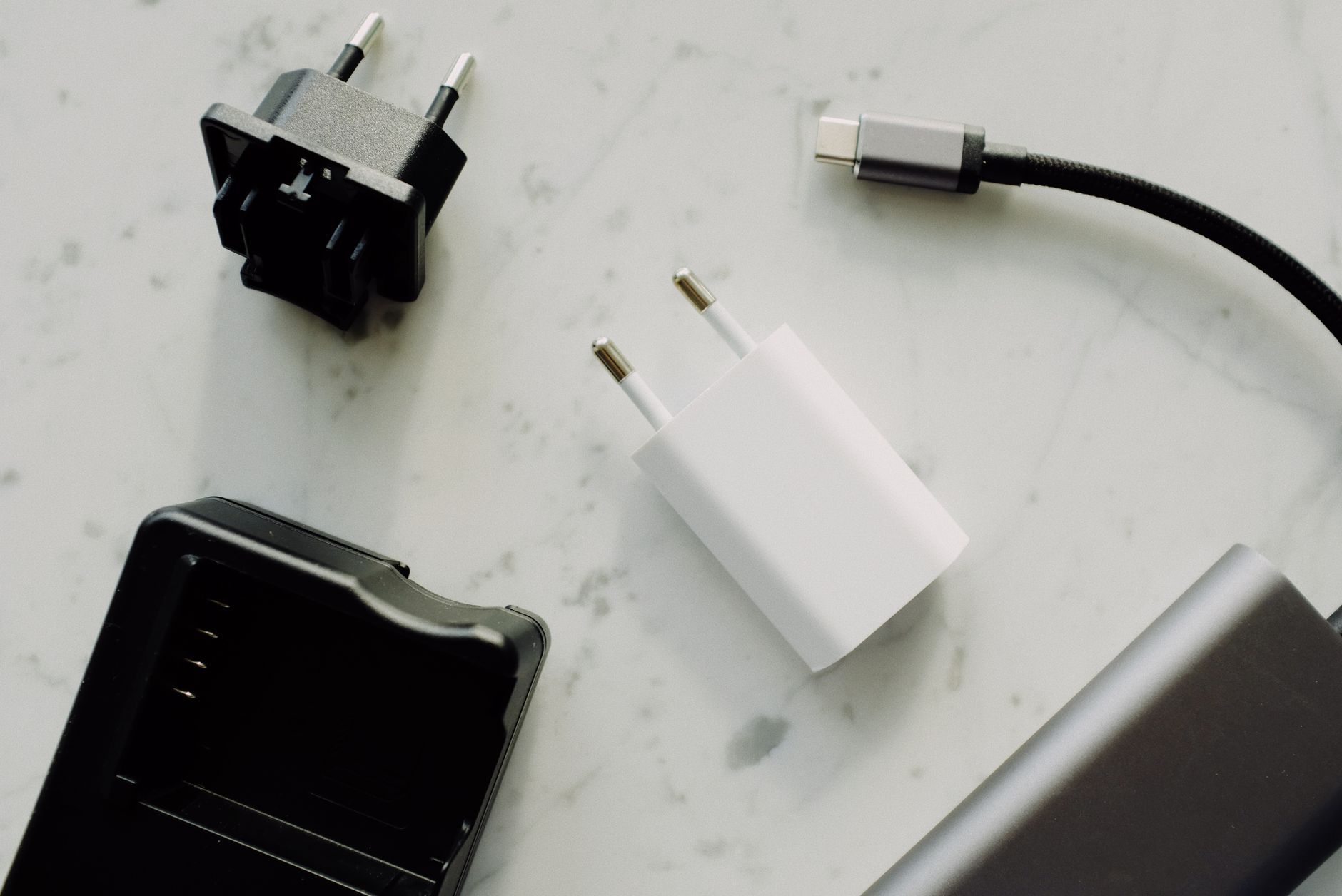 Imagen referencial: Primer plano de USB-C y adaptadores sobre una superficie de mármol, destacando esenciales de la electrónica moderna.