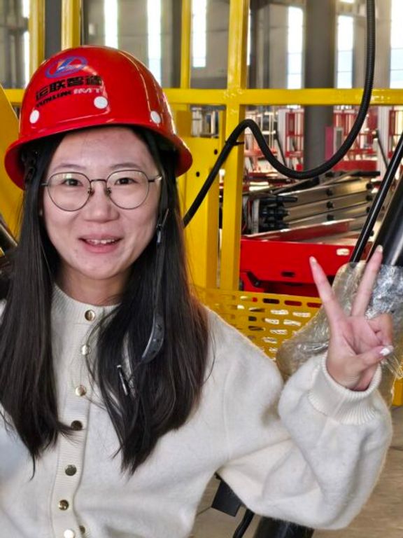 Jing He mit Schutzhelm in einer Werkshalle in China