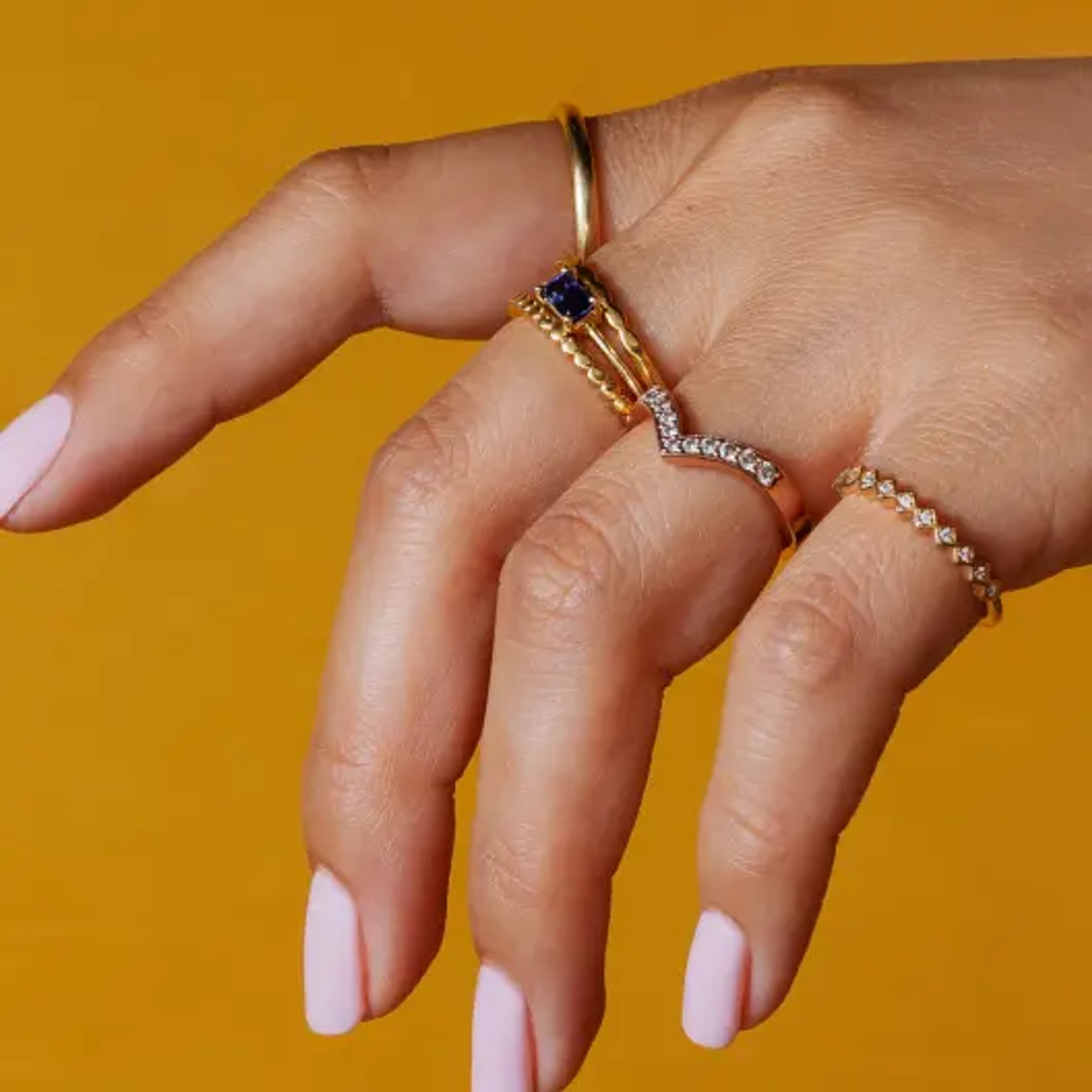 A hand with an assorted style of rings on each finger