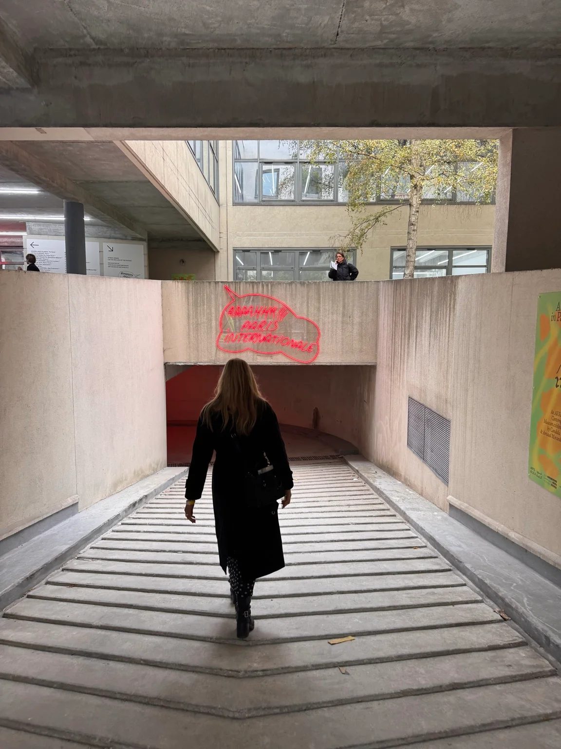A visitor entering Paris Internationale 2026 beneath the fair’s red neon sign.