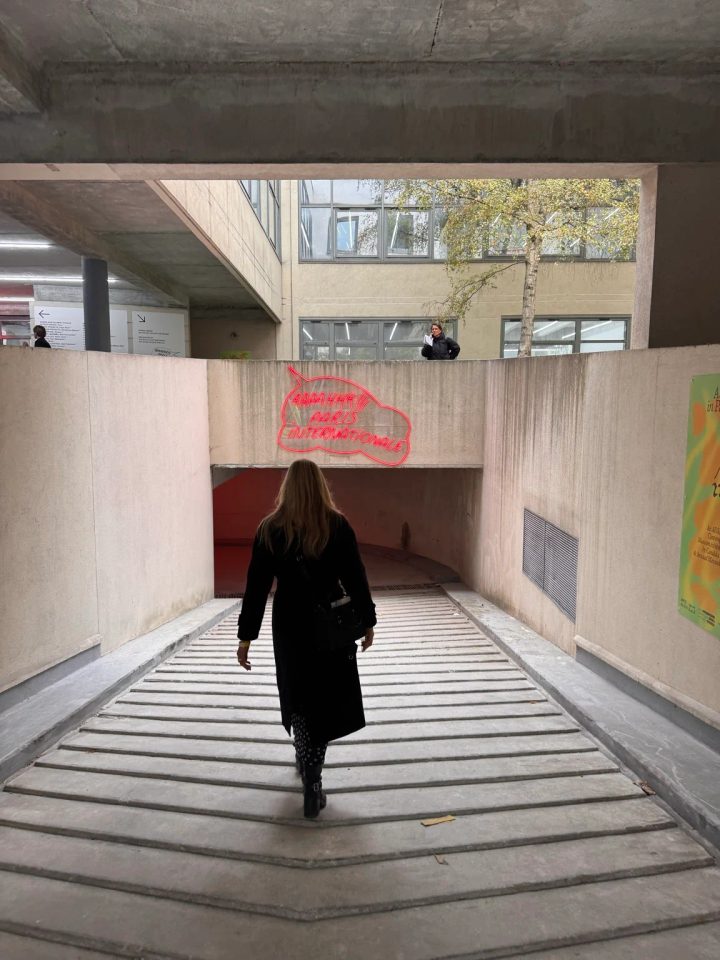 A visitor entering Paris Internationale 2026 beneath the fair’s red neon sign.
