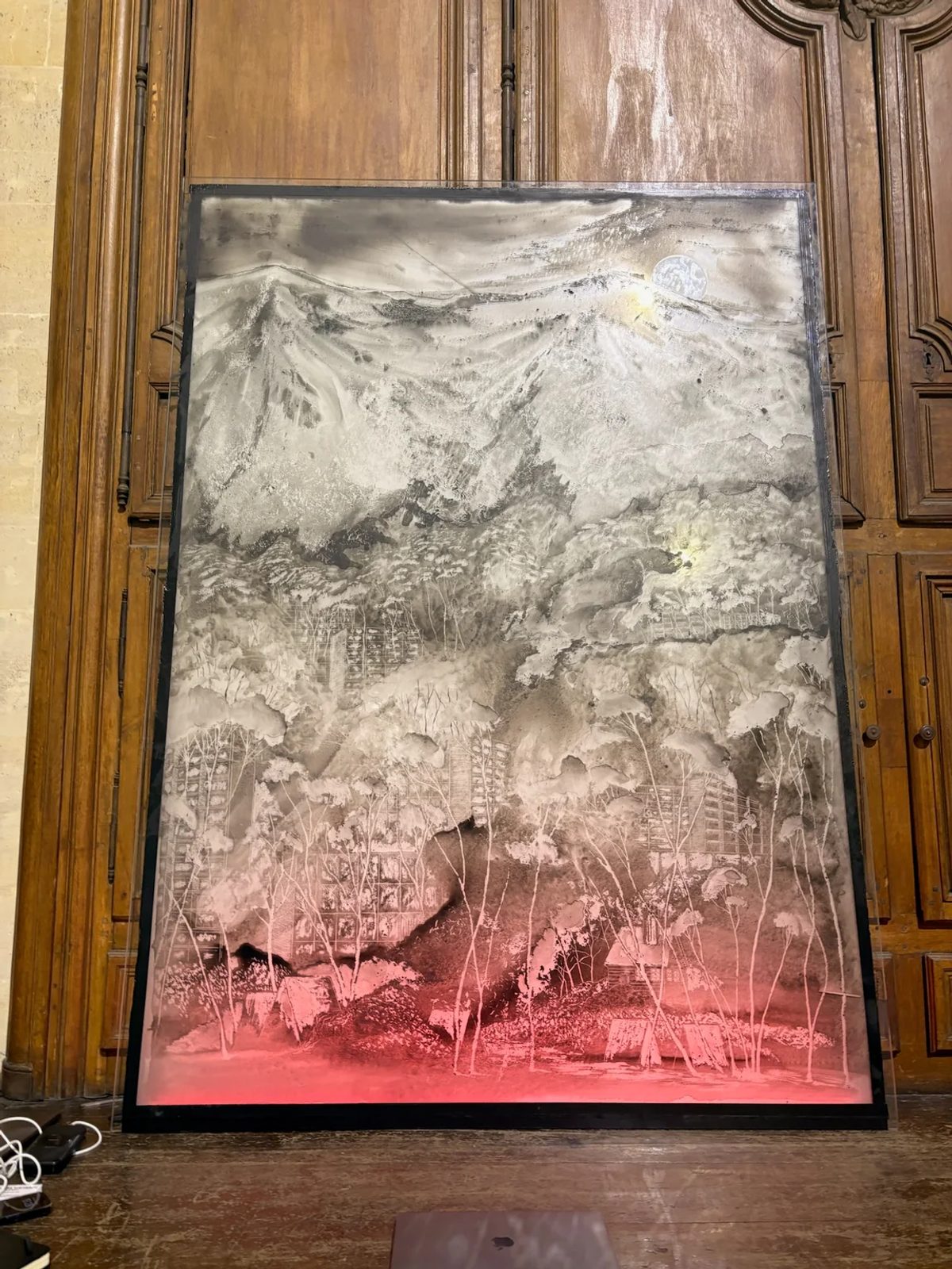 A glass landscape template by Josef Achrer, lit red along its base and displayed against wooden panelling.