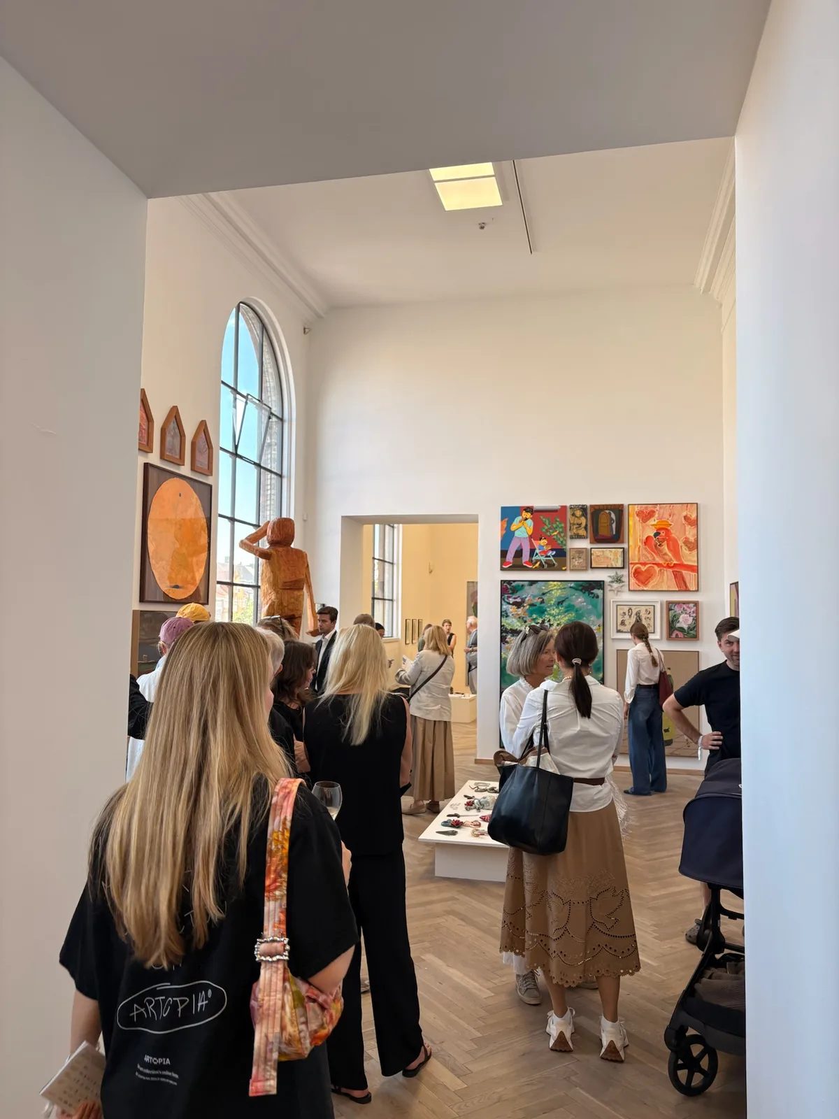 Visitors viewing paintings and sculpture inside the bright galleries of Kunsthal Charlottenborg during CHART.