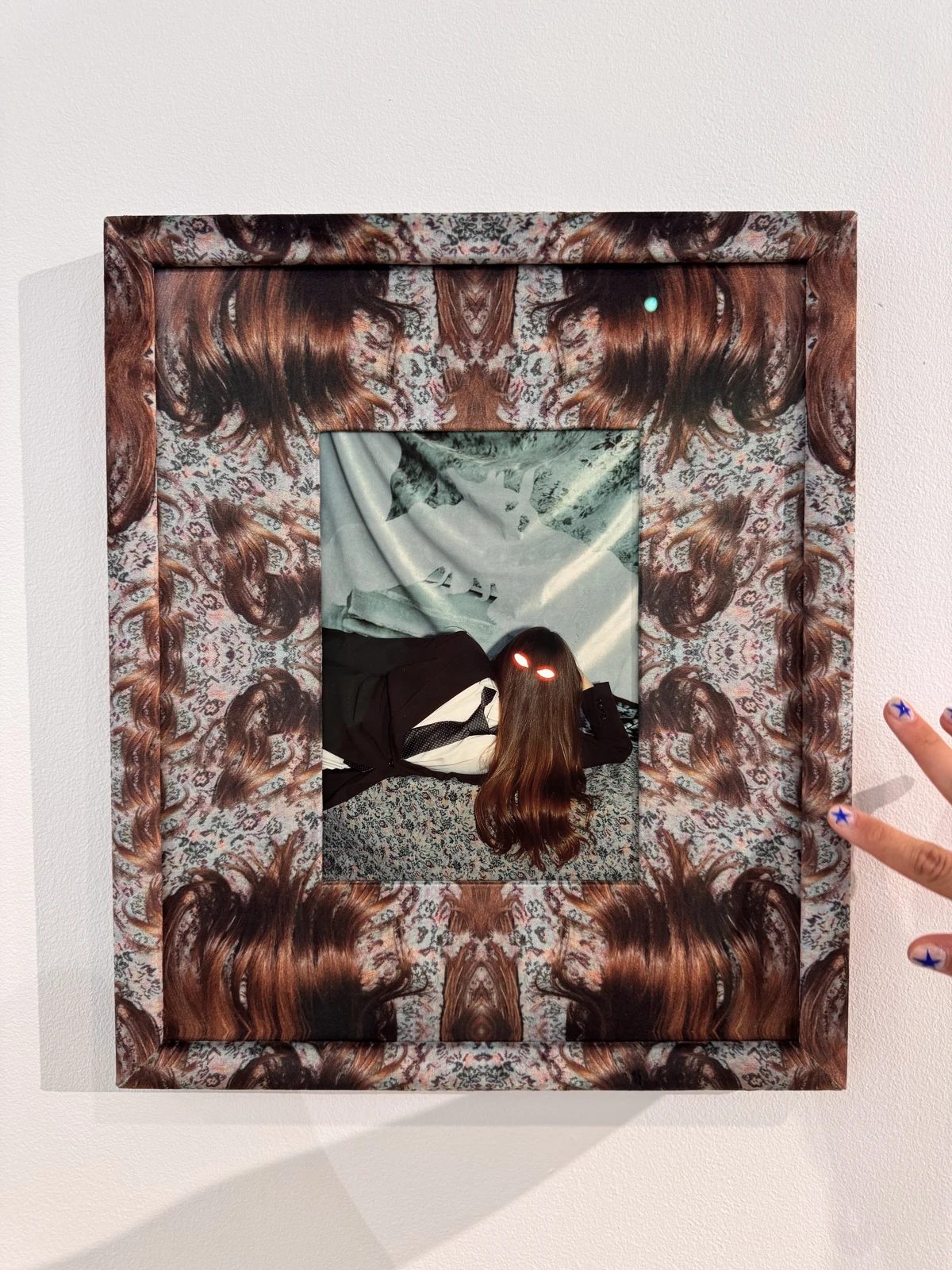 A photographic composition with a female figure and a patterned frame at Galerija ASNI.