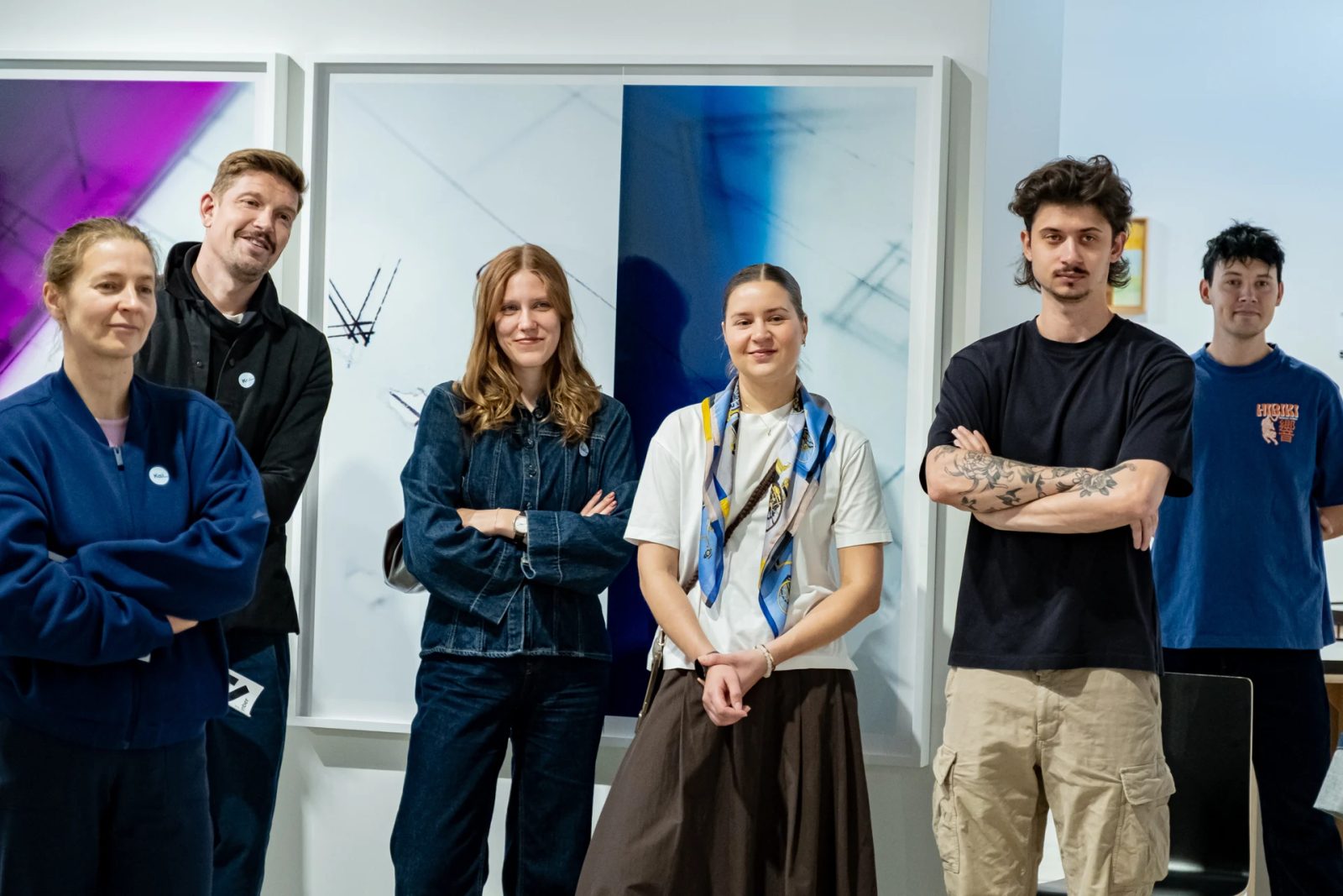 Six people standing in front of framed photographic artworks at FOTO Tallinn.