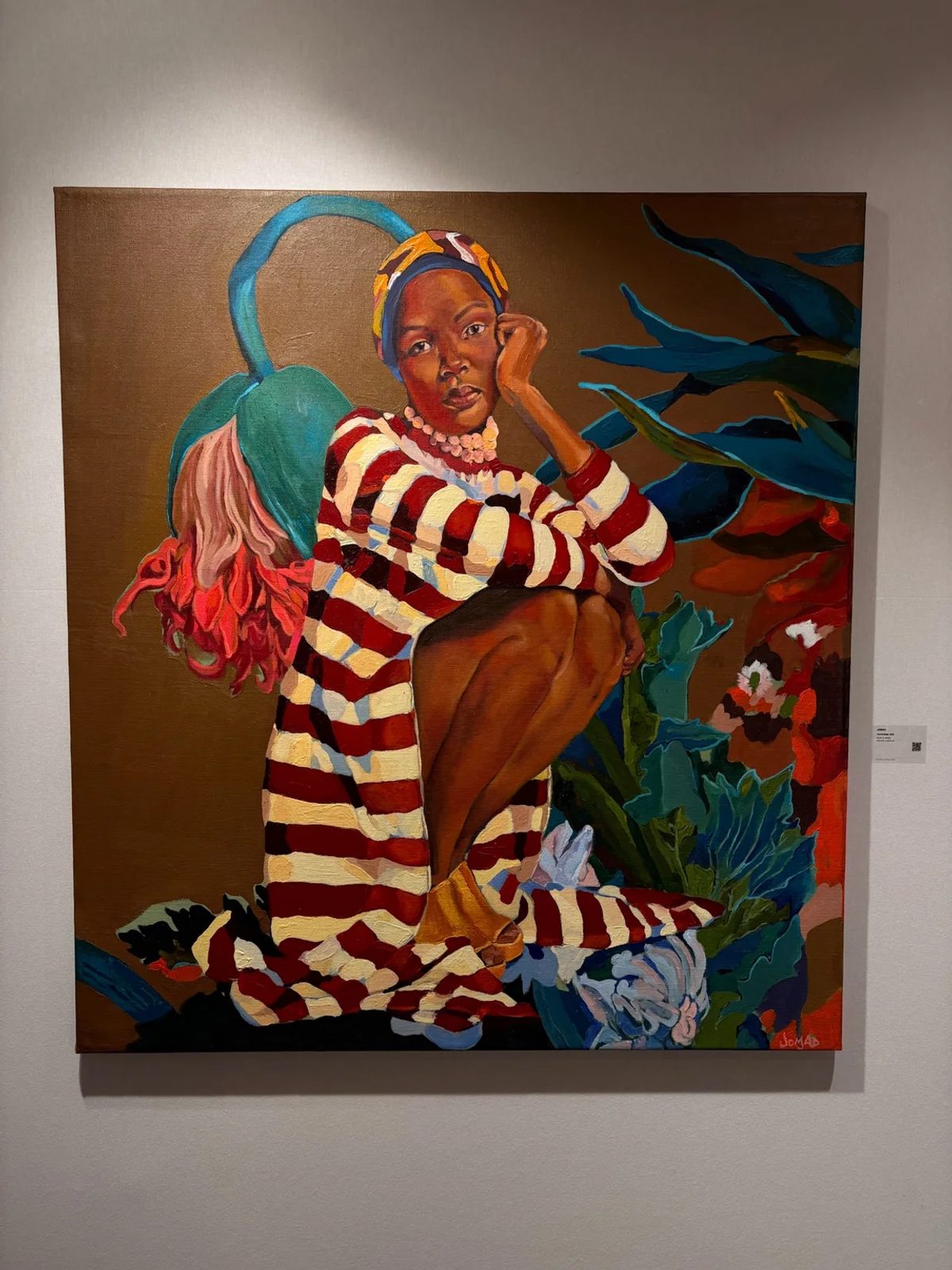 A painting by Jomad of a seated woman in a red and cream striped dress, surrounded by oversized flowers.