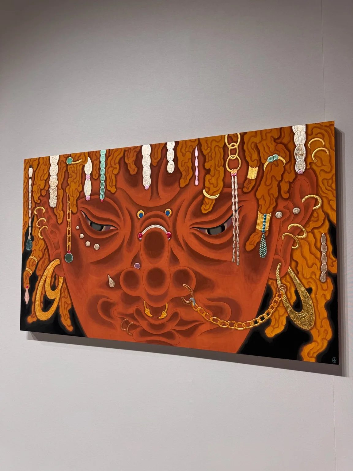 Tseng Chien-Ying’s Vesper (2026), an orange-red face adorned with chains, earrings and piercings, at Asia NOW.