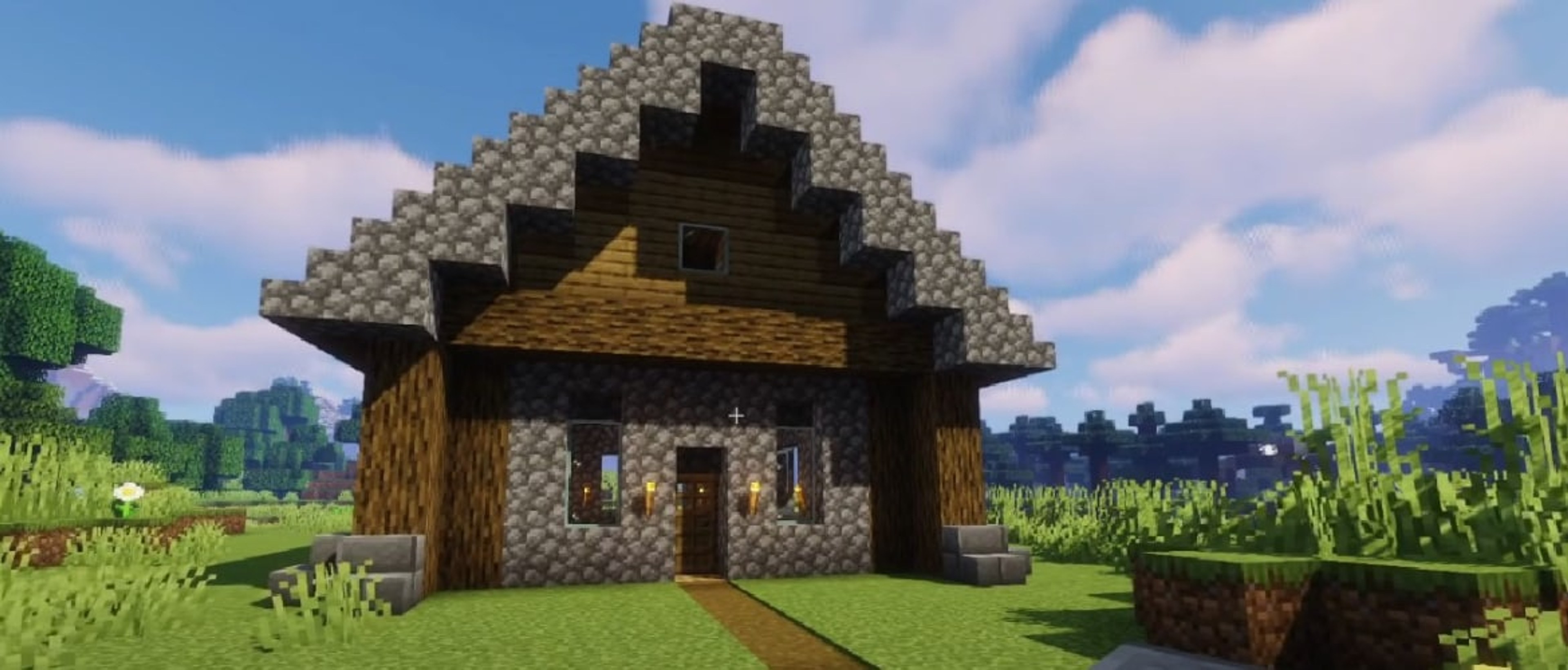 A small Minecraft house with a peaked roof, cobblestone walls, logs, and torches.