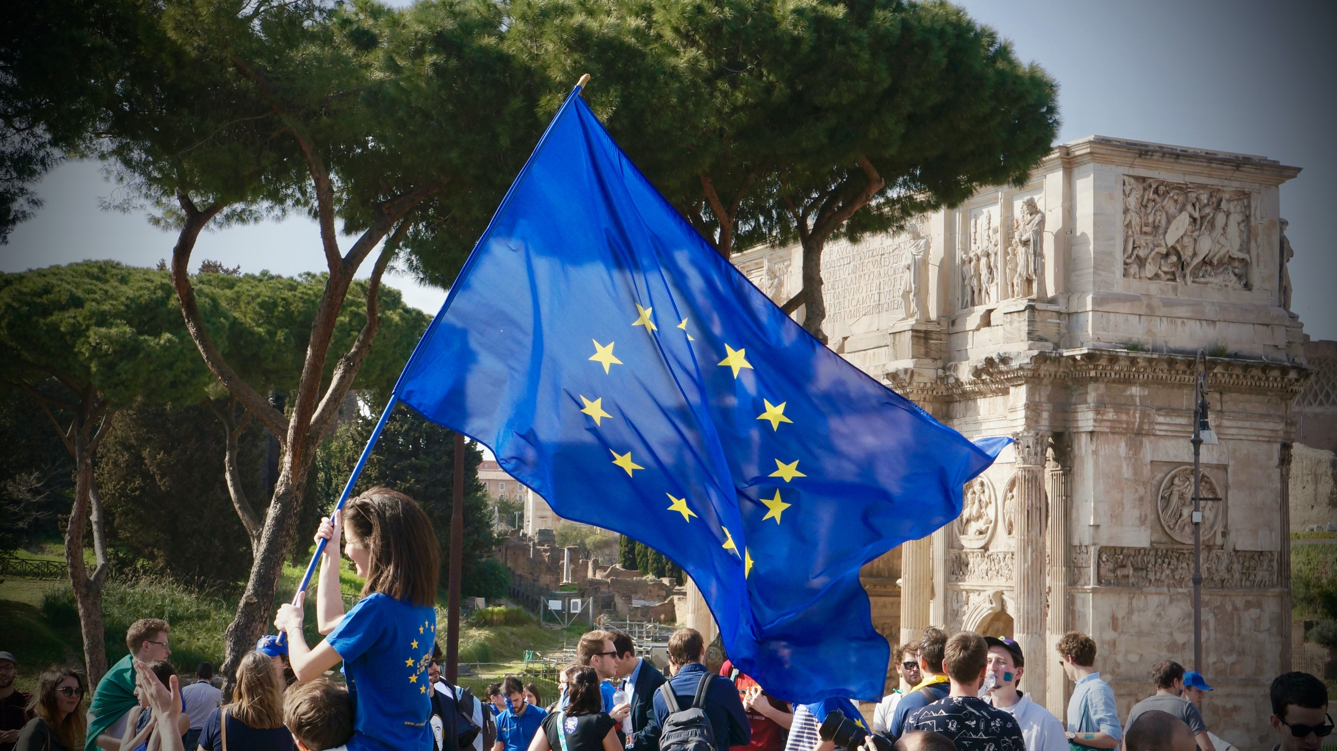 Person bærer et EU-flagg foran en folkemengde