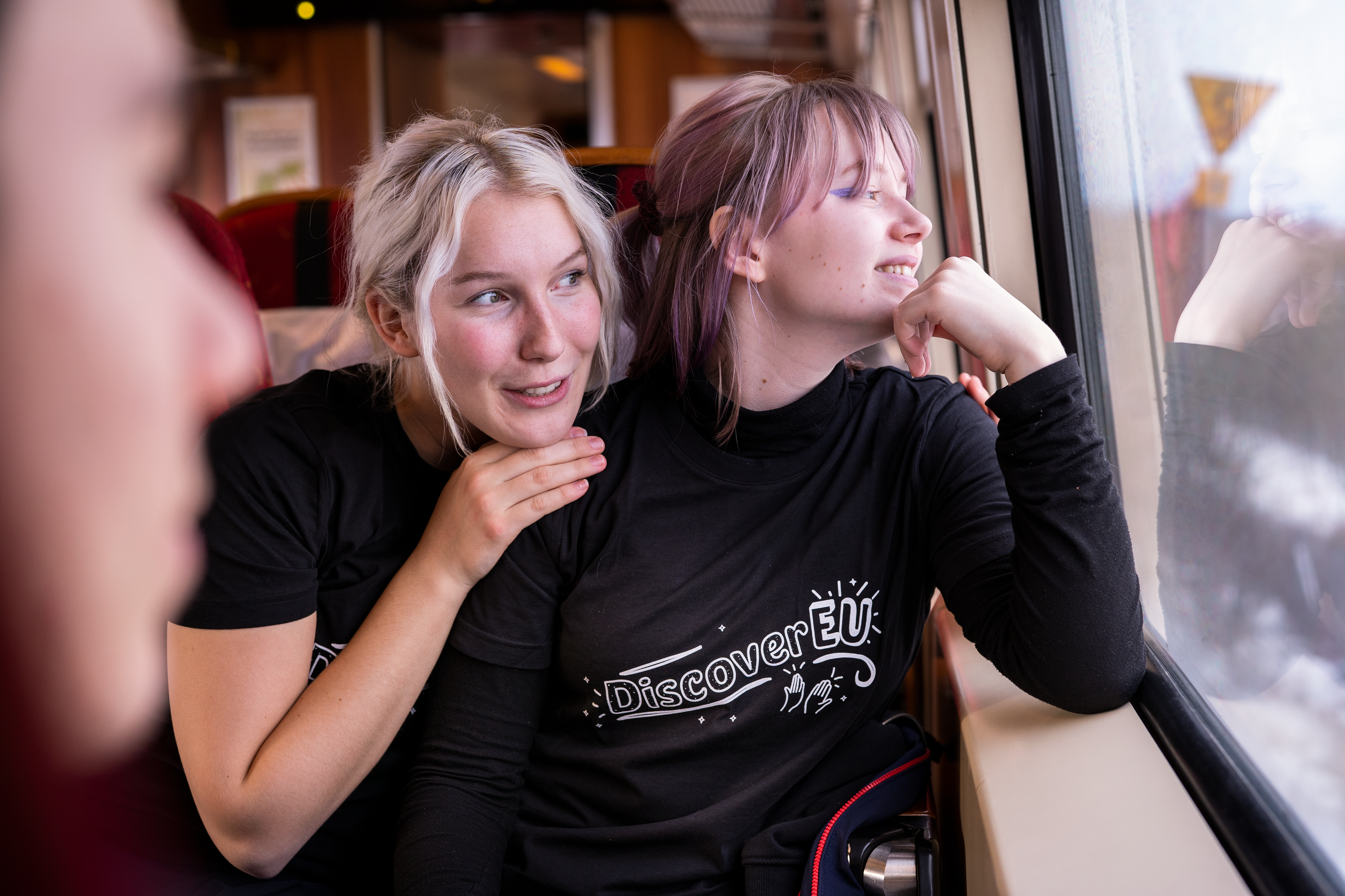 To unge jenter på et tog som gleder seg til reisen de skal ut på