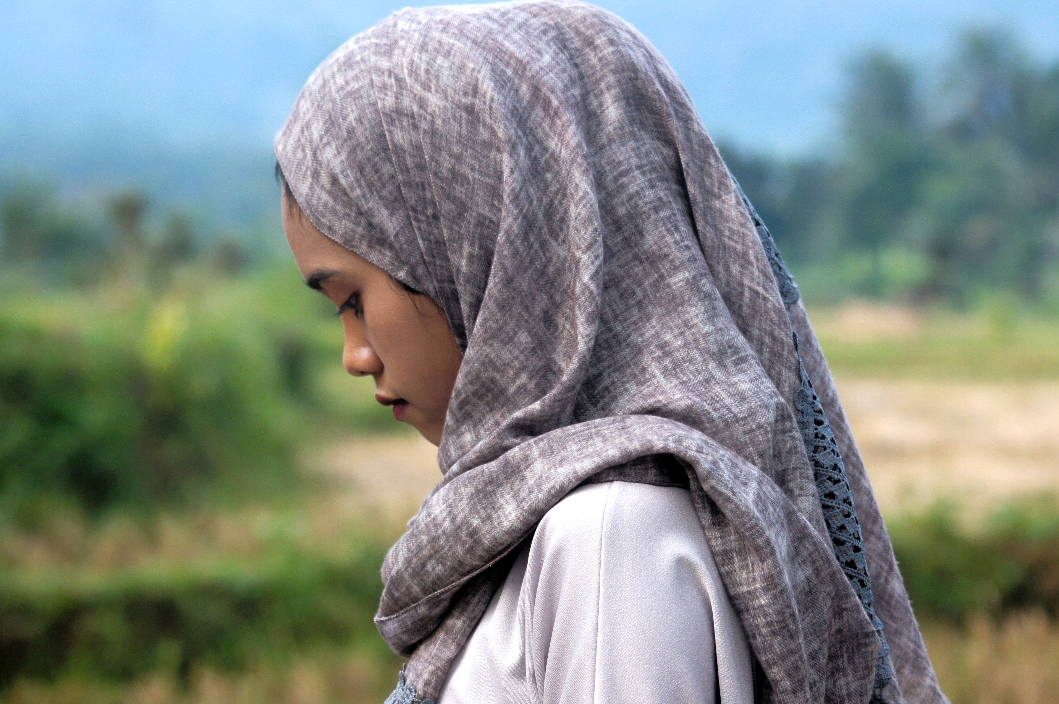 Jente i begynnelsen av tenårene med hijab ser nedstemt ut.