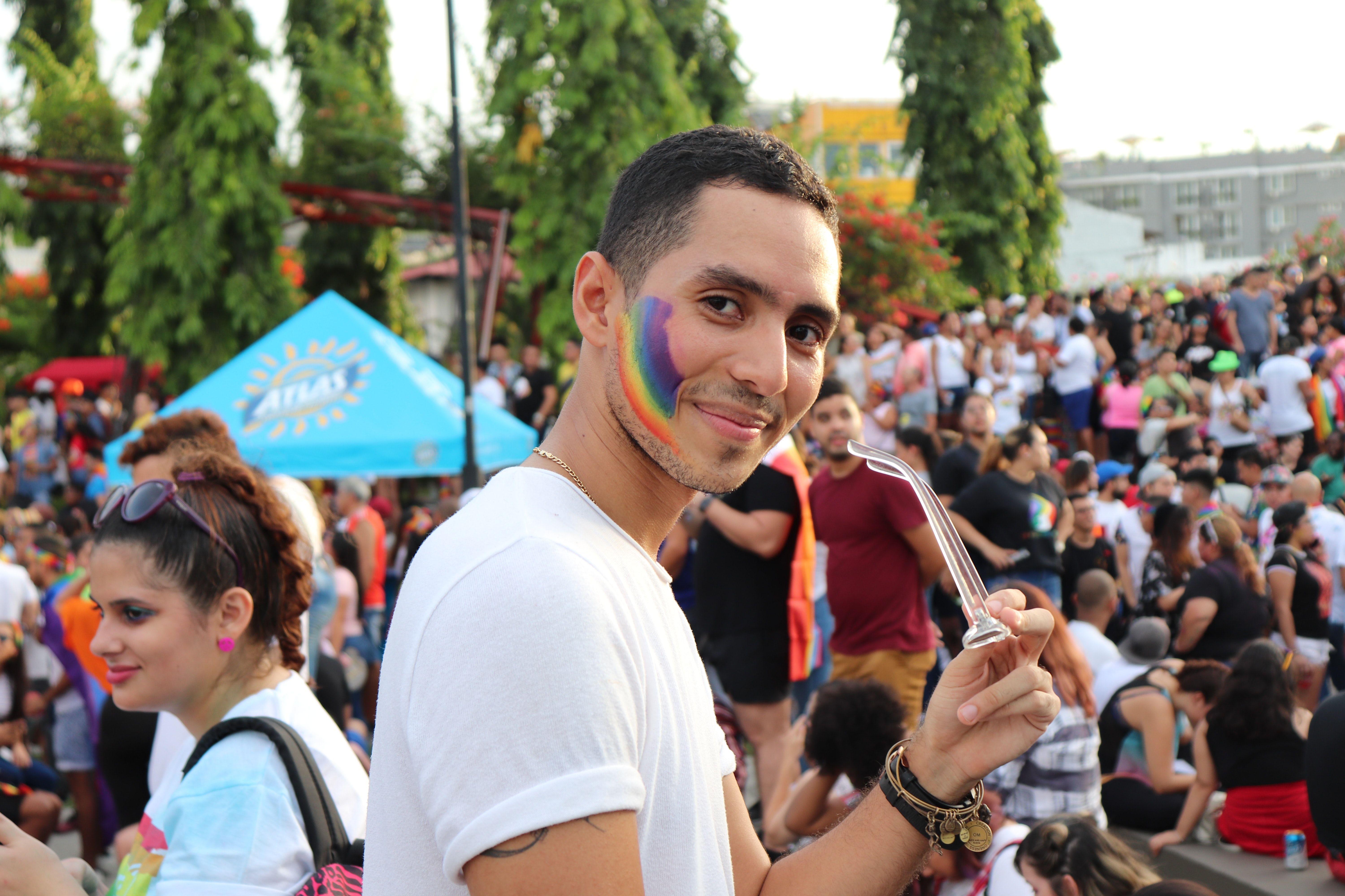 Ung gutt feirer Pride med regnbue malt på kinnet