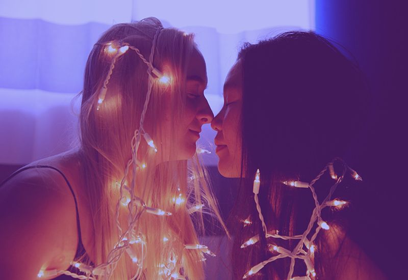 To jenter som lener seg inn mot hverandre for å kysse