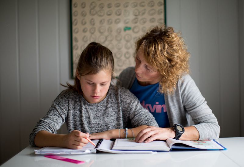 Jente får hjelp til leksene (foto: Tine Poppe / bufdir.no)