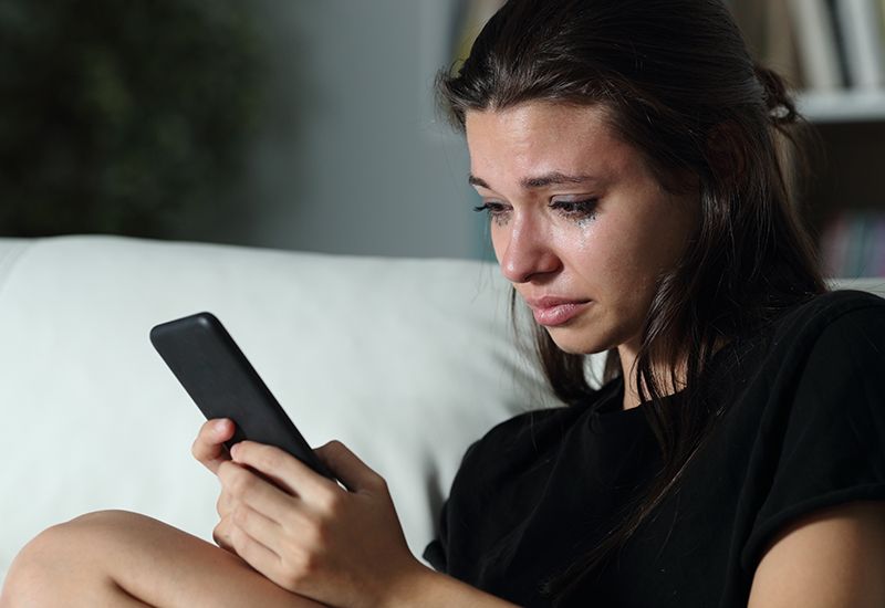 Jenter ser på mobilen og er lei seg (colourbox.com)