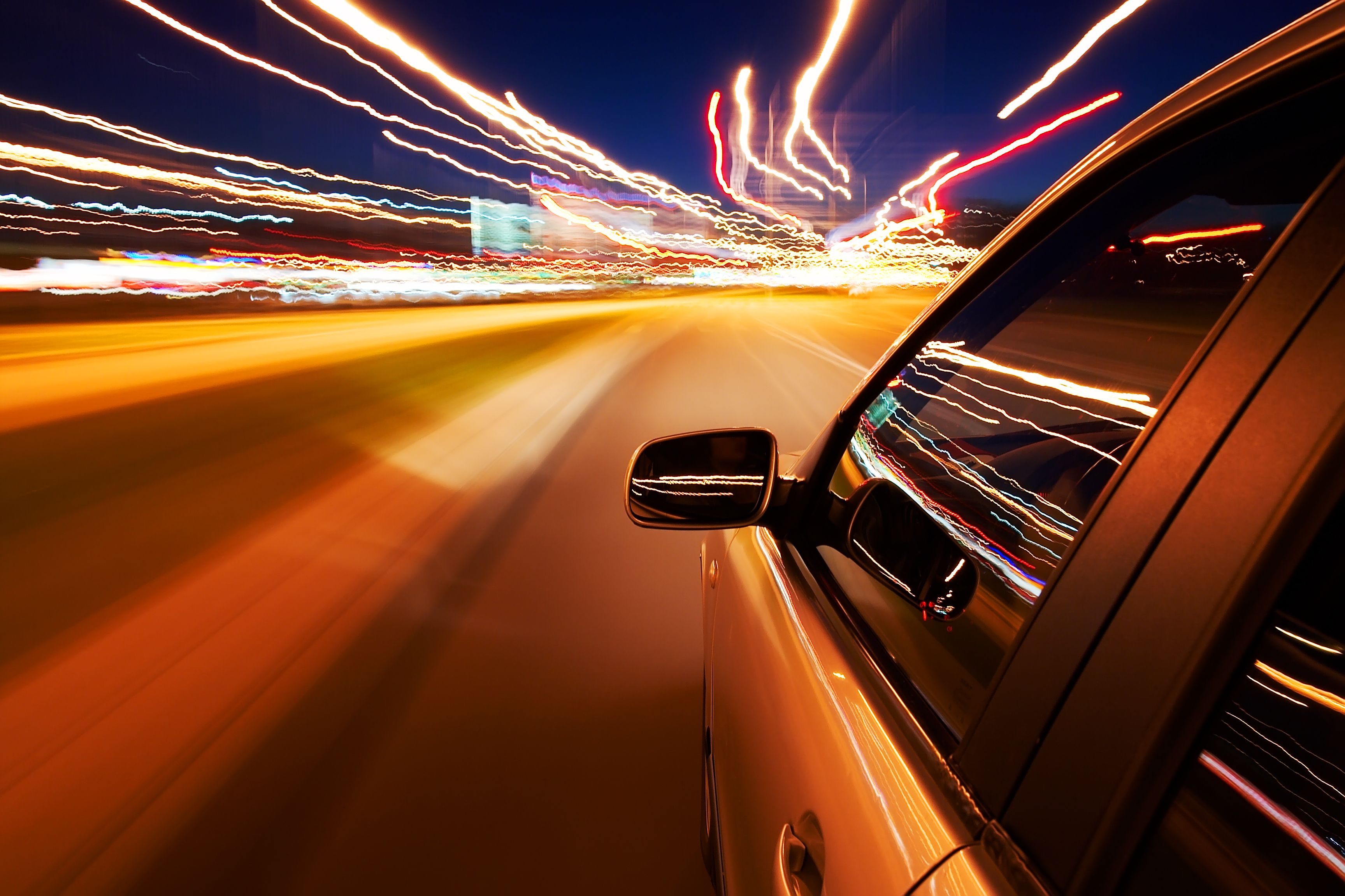 Tett utsnitt av bil som kjører i høy hastighet på kveldstid.