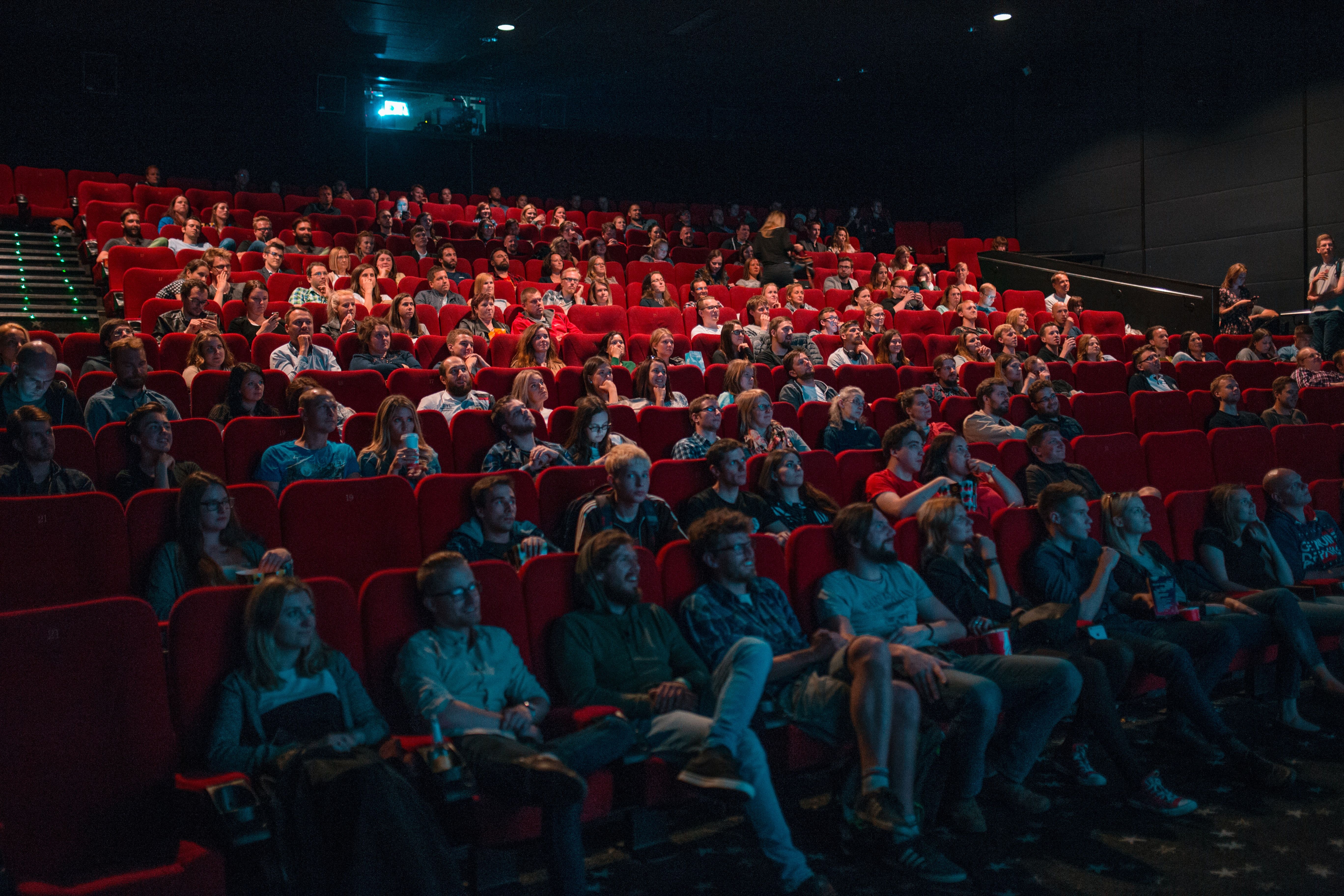 Unge mennesker i en mørk kinosal som følger med på filmen som vises på skjermen
