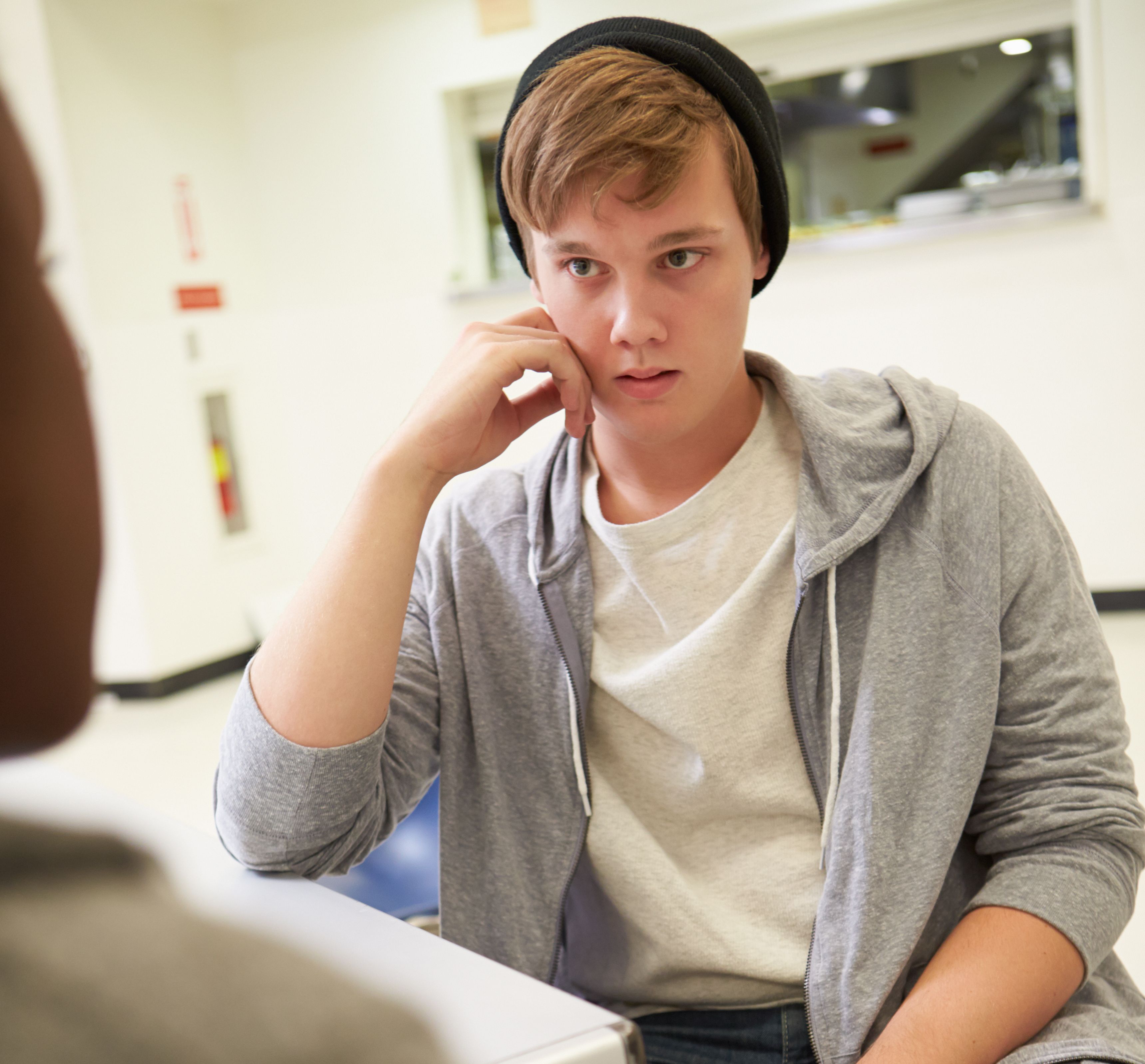 Gutt som snakker med en person på en helsestasjon.
