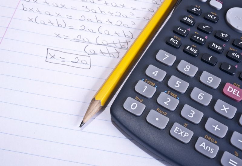 En matteprøve ligger på bordet sammen med en blyant og en kalkulator