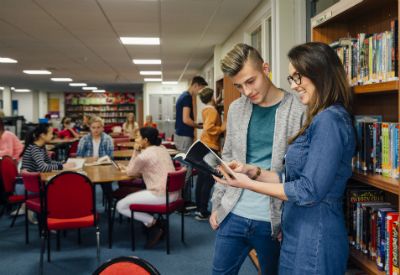 Gutt og jente på skolebibliotek (colourbox.com)