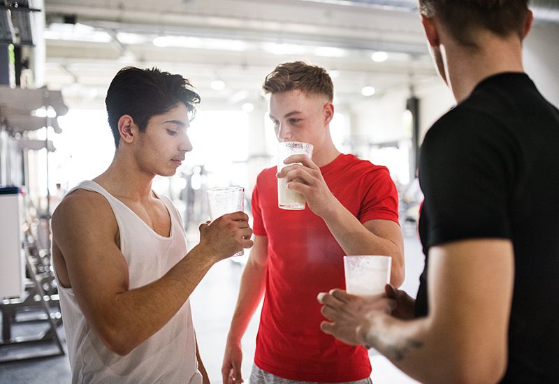 Gutter drikker proteinshake på treningssenter (colourbox.com)