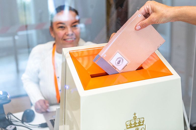 Person legger en stemmeseddel i valgurnen