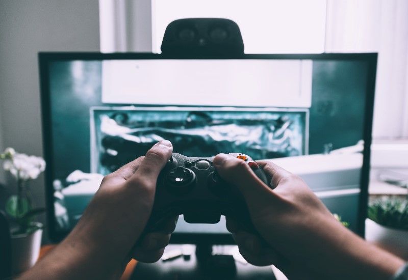 Håndkontroll til spill foran skjerm. Foto: Unsplash.