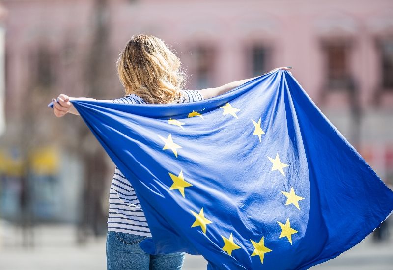 Jente som holder EU-flagg. Foto: Unsplash.