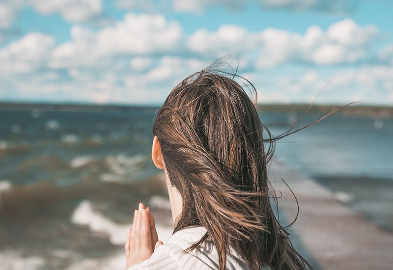 Jente ser ut over havet (Foto: Joshua Reddekopp på Unsplash.com)