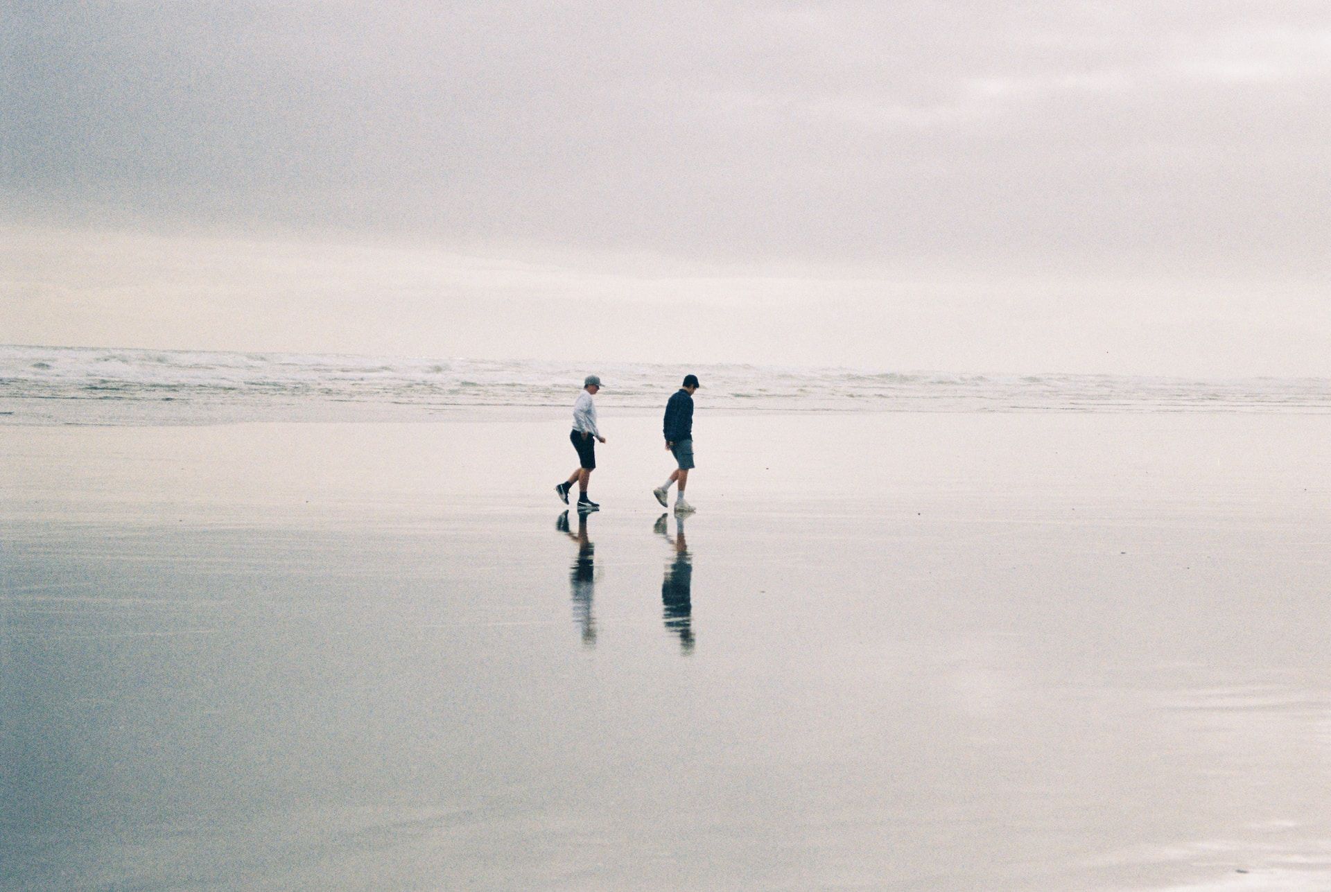 Foto av to gutter som går langs en stor strand.