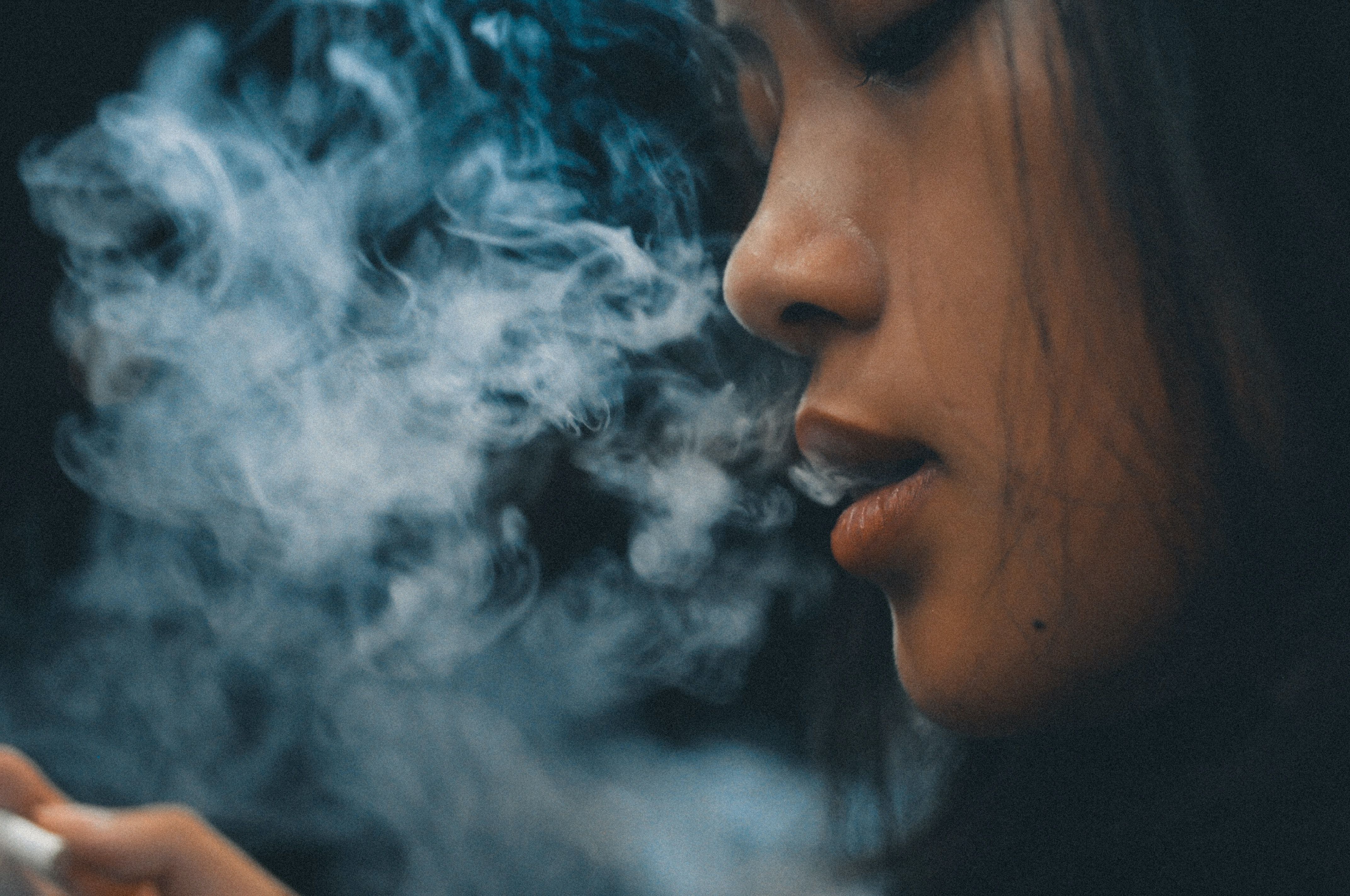 Bilde av ung jente som puster ut røyk