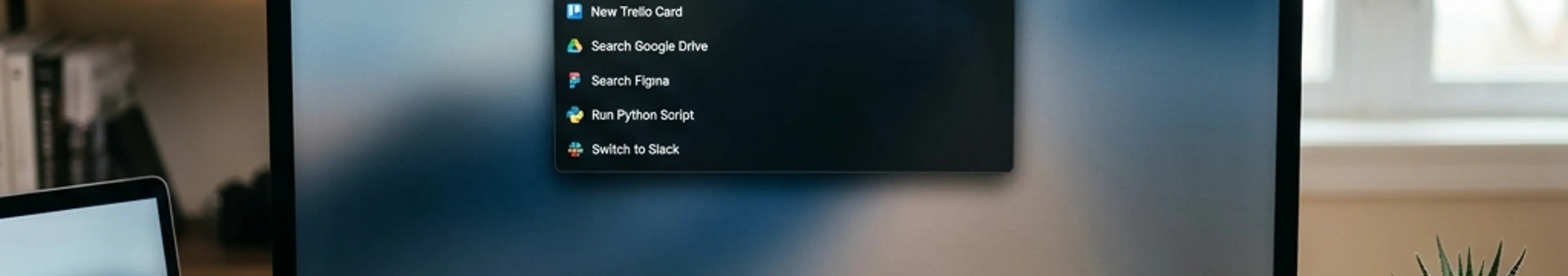 Raycastのランチャーインターフェースが表示されたMacのデスクセットアップ