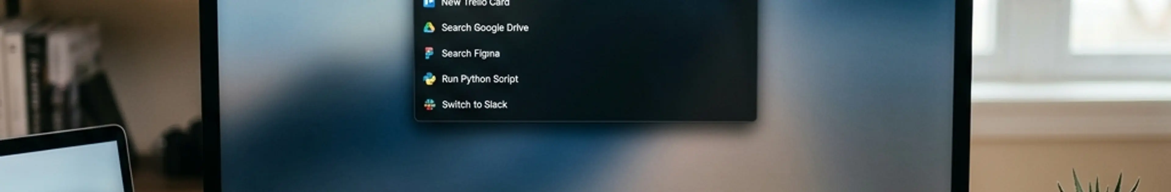 Raycastのランチャーインターフェースが表示されたMacのデスクセットアップ
