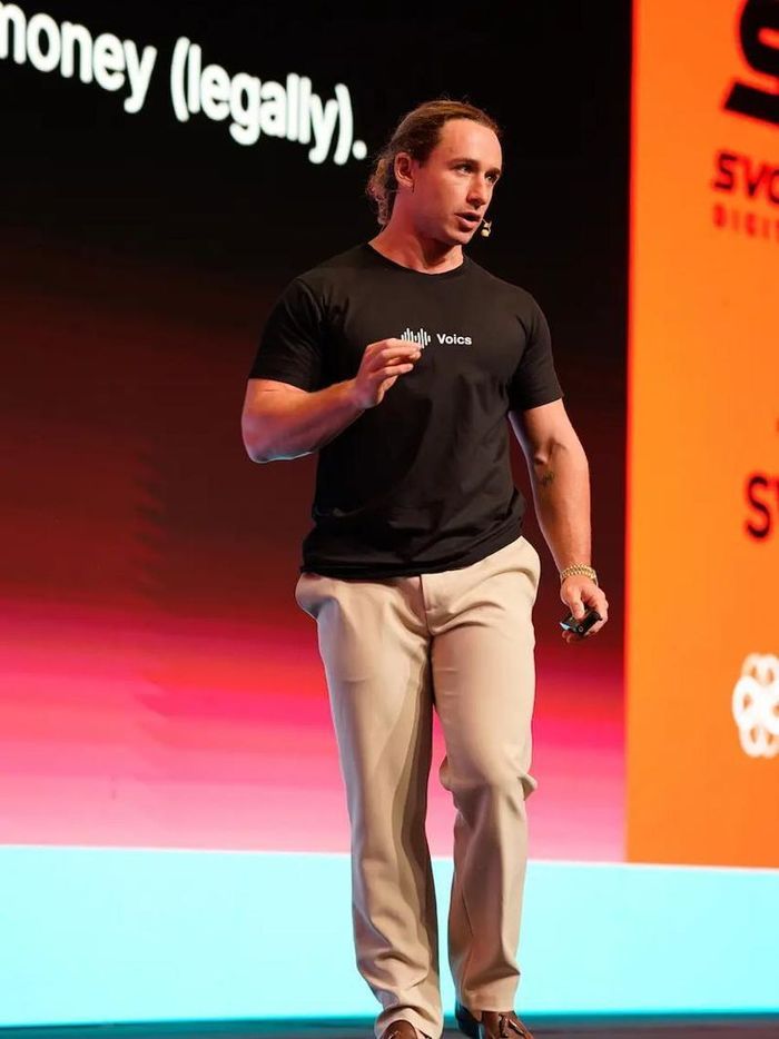 Darren Lee speaking on stage at a Voics keynote