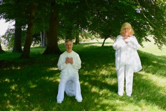 Ruthie and Alan in white floaty clothes under the trees