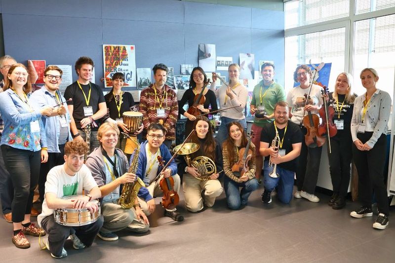 A cohort of Musicians of Change students holding their instruments. 
