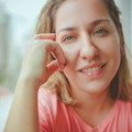 Abelia Torres, reviewer — professional headshot of a smiling woman in a pink shirt by a window.