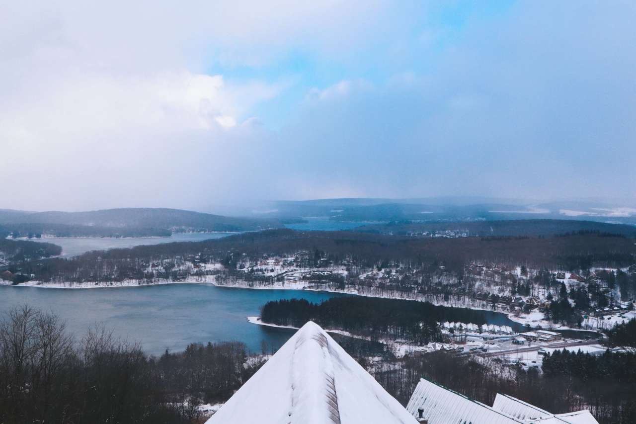 Snow-covered Maryland lake and forest landscape from above