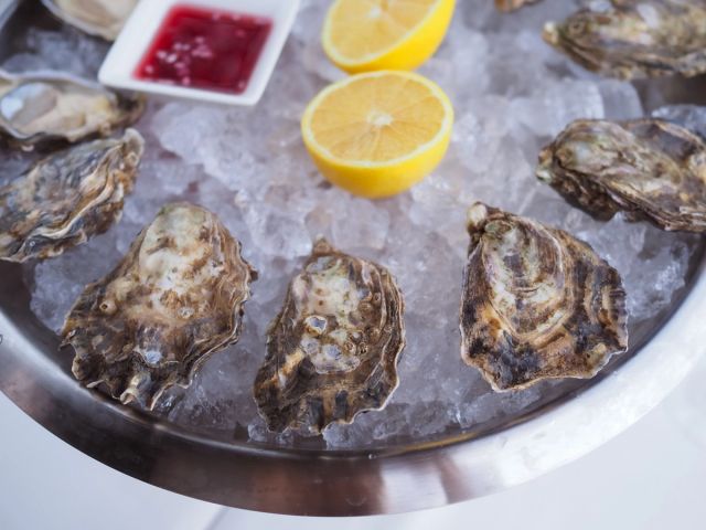 Fresh oysters served on ice with lemon and sauce