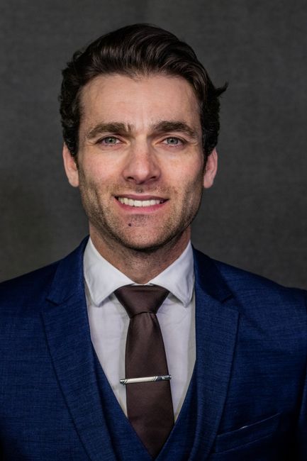 Marcus Bell, reviewer — professional headshot of a smiling man in a blue suit and tie.