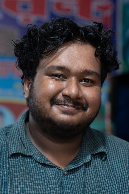 Tom Kowalski, reviewer — professional headshot of a smiling man with curly hair in a casual checkered shirt.